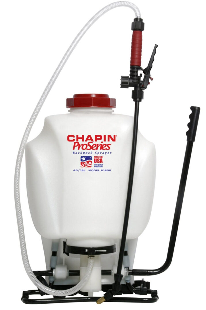 A white and red sprayer sitting on top of a floor.