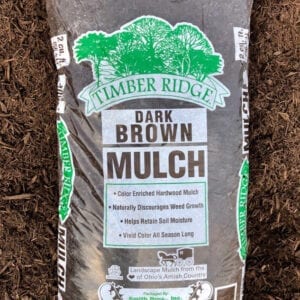 A bag of mulch sitting in the dirt.