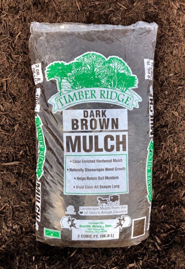 A bag of mulch sitting in the dirt.