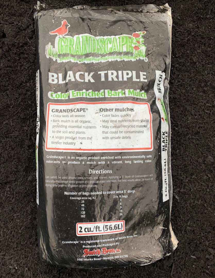 A bag of black triple is sitting on the ground.